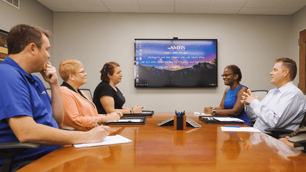 ambs call center's team sitting to discuss phone etiquette tips