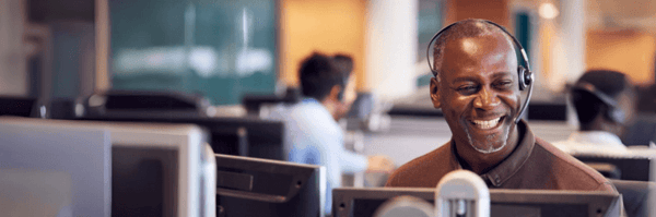 Male call center agent smiling on call